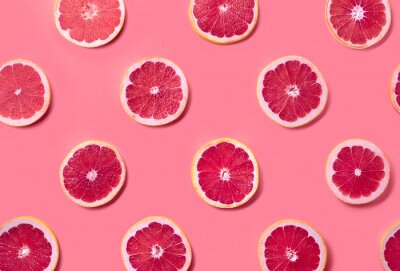 Behang Grapefruitplakken op een roze achtergrond