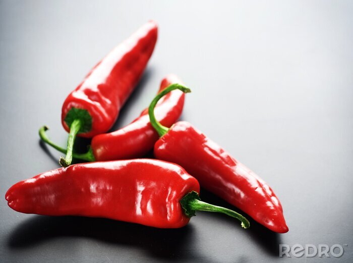 Behang Rode paprika's op een donkere achtergrond