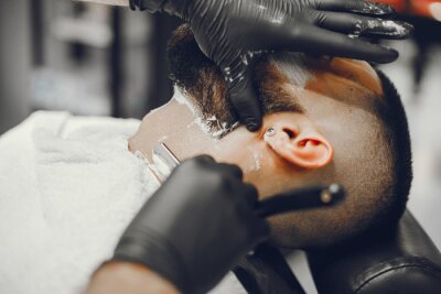 Canvas A man in a barbershop. Clipping beard in the barber. Rest in hairdressing salon