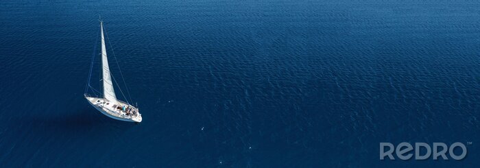 Canvas Aerial drone ultra wide photo of beautiful sail boat cruising in Aegean deep blue sea
