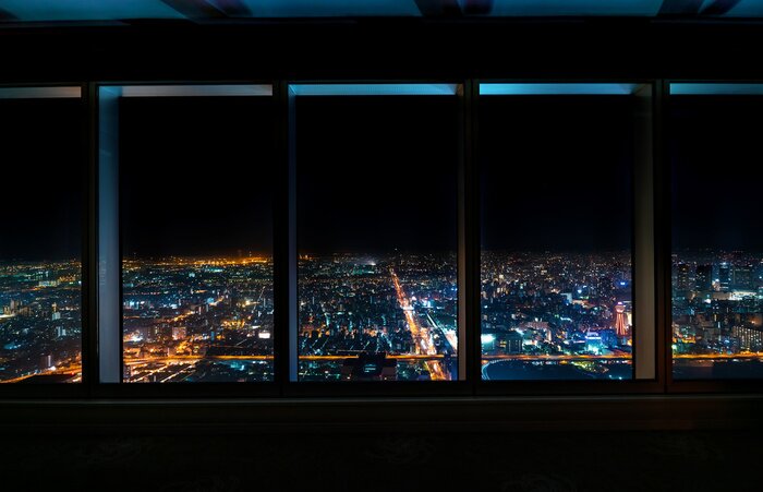 Canvas Aerial view of the Osaka skyline at night through a skyscraper window