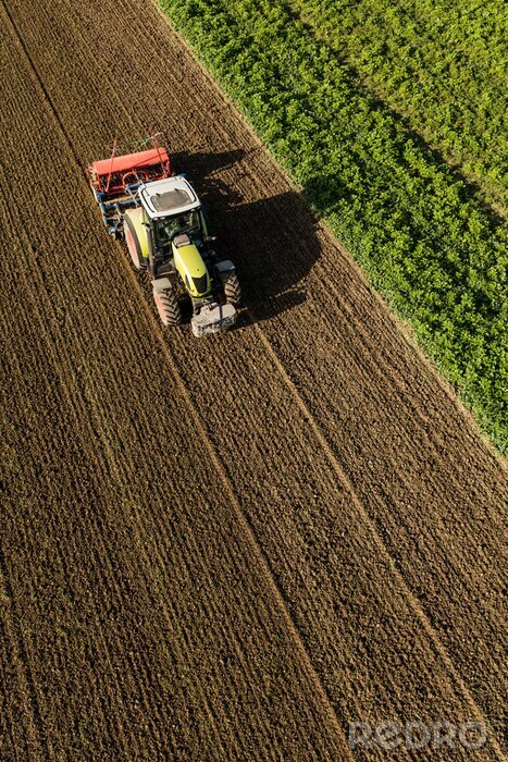 Canvas aerial view of the tractor on the harvest field