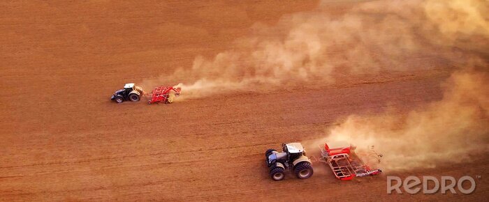 Canvas aerial view of two agriculture tractors with plows. Plowing the field