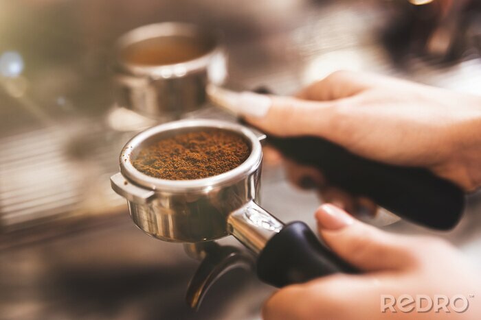 Canvas Barista woman holding coffee holder with ground coffee near professional coffee machine close up
