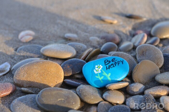 Canvas blue stone with the inscription be happy on the beach among the stones