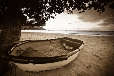 Canvas boot op een strand met zee op de achtergrond