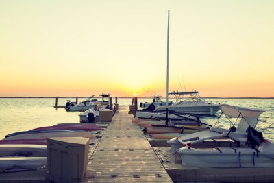 Canvas boten afgemeerd aan de pier bij zonsondergang