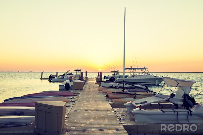 Canvas boten afgemeerd aan de pier bij zonsondergang