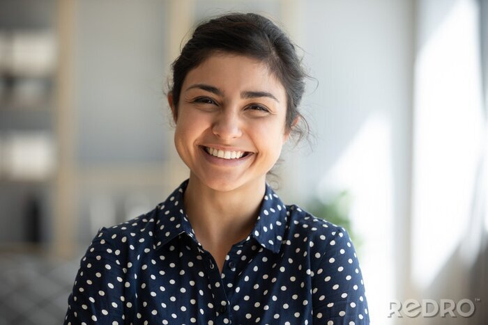 Canvas Cheerful indian girl standing at home office looking at camera