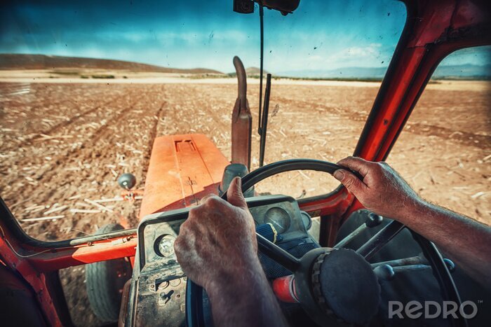Canvas Close-up handen van de boer, zit binnen in de trekkerhut