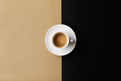 Canvas Cup of coffee on gold black background. Minimalistic flat lay. Top view.