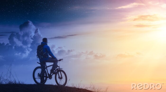 Canvas Cyclist on a mountain top between day and night