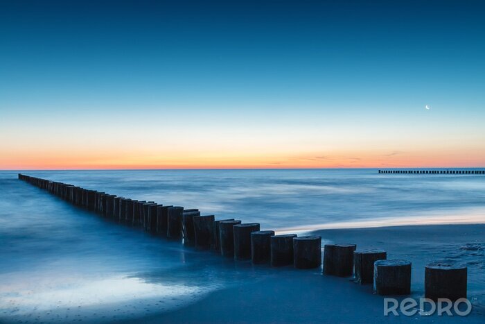 Canvas De zee en golfbreker na zonsondergang