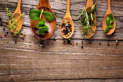 Fotobehang Diverse specerijen en kruiden gerangschikt op houten lepels.