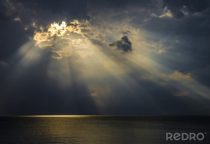 Canvas Donkere zee met een doordringend licht de zon