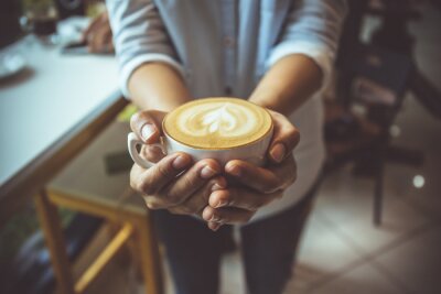 Canvas Een kopje koffie in de handen van een vrouw