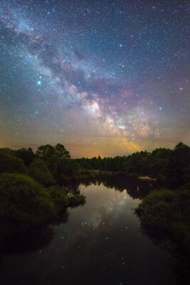 Een sterrenstelsel dat reflecteert in de wateren van een meer