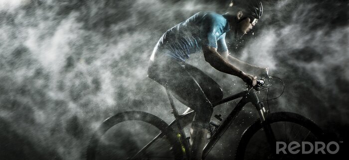 Canvas Fietser fietsen op mountainbike met regenachtig, mistig op zwarte achtergrond.
