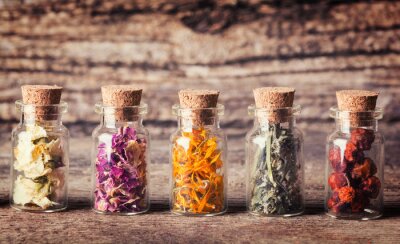 Canvas Glazen flesjes met kruiden op een ruwe houten achtergrond