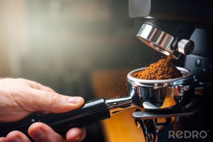 Canvas ground coffee pouring into a portafilter with a grinder