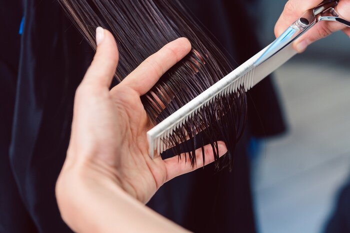 Canvas Hairdresser cutting and styling hair of woman in her shop