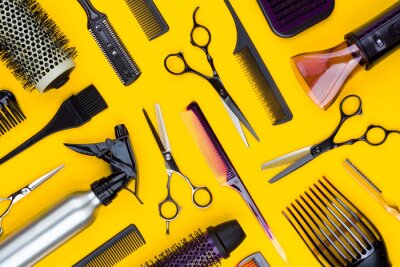 Hairdresser tools and combs tools on yellow background, top view