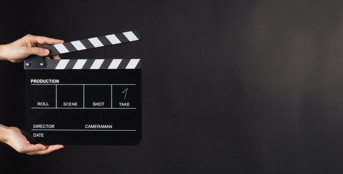 Canvas Hand is holding Black clap board or movie slate  use in video production , movie ,film, cinema industry on black background.It have write in number.