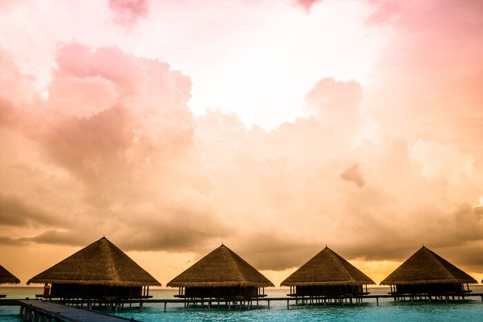 Canvas Houten huisjes aan een azuurblauwe lagune