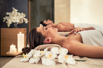 Canvas Jonge man ontspannen met zijn partner op massage bedden in moderne spa en wellness-centrum