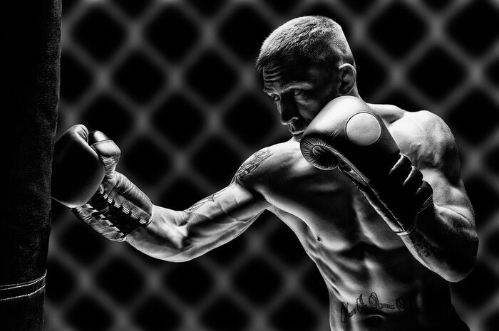 Canvas Kickboxer punches the bag. Training a professional athlete. The concept of mma, wrestling, muay thai.