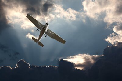 Canvas Kleine vaste vleugel vliegtuig tegen een stormachtige hemel