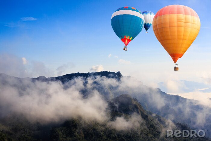 Canvas Kleurrijke heteluchtballonnen vliegen over de berg