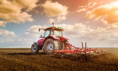 Landbouwer in tractor voorbereiding land met zaaibed cultivator