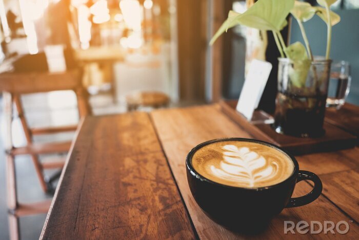 Canvas Latte cup on wooden table blur coffee shop background