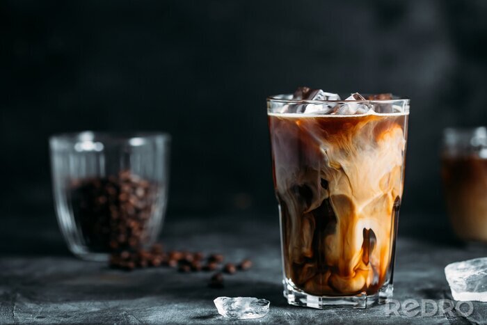 Canvas Milk Being Poured Into Iced Coffee on a dark table
