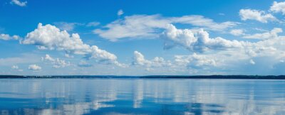 Canvas Panorama of calm lake, Kama river blue sky with clouds reflected in the water.