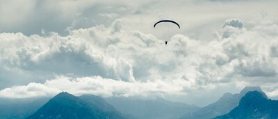 Canvas Paraglider over bergen en bewolkte hemel achtergrond