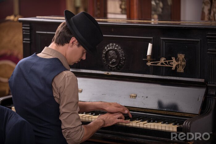 Canvas Portret van een muzikant in pak en met zwarte hoed en het spelen van de pian