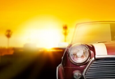 Canvas Retro auto kop licht op straat in de zonsondergang achtergrond