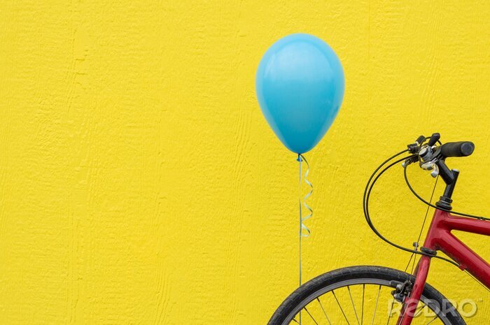 Canvas Rode fiets met een blauwe ballon tegen een fel gele muur.