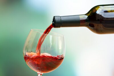 Rode wijn het gieten in wijnglas, close-up