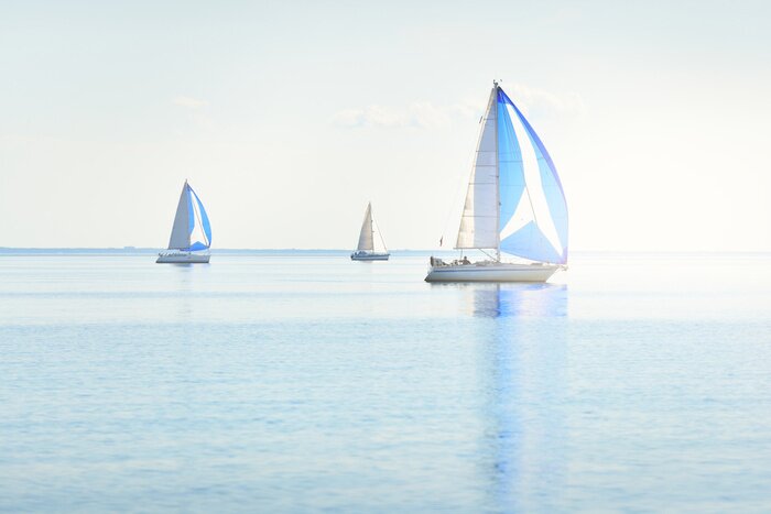 Canvas Sailing yacht regatta. Modern sailboats racing with blue spinnaker sails. Clear summer day. Kiel, Germany. Sport and recreation, transportation, private wessel, vacations