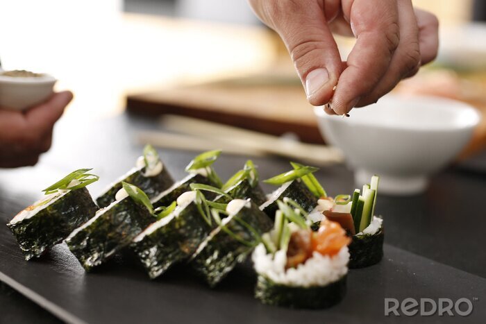 Canvas Sushi meester przyrządza futomaki. KLASYCZNE pit rolki futomaki Podané na kamiennym talerzu
