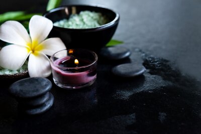 Canvas Thai Spa.  Top view of white Plumeria flower setting for massage treatment and relax on concrete blackboard with copy space.  Green leaf with black stones pile for spa therapy. Healthy Concept.