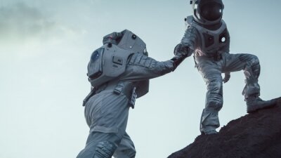 Twee astronauten die elkaar helpen