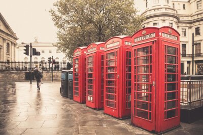 Canvas Vintage stijl rode telefooncellen op regenachtige straat in Londen