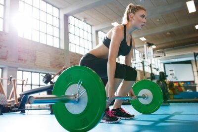 Canvas Vrouw in een sportschool doet zwaar gewicht oefeningen
