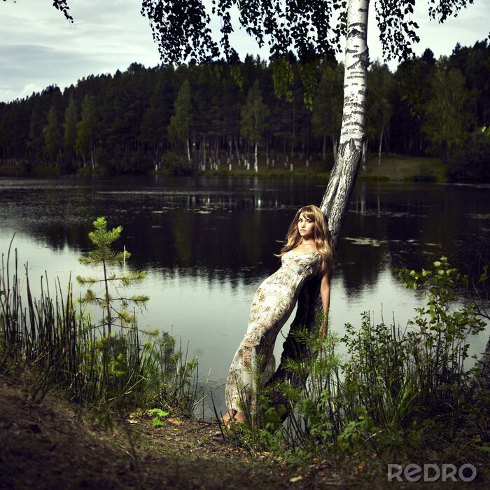 Canvas Vrouw leunend tegen een boom