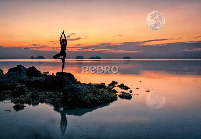 Canvas Vrouw op rotsen bij de zee in yogapositie