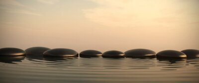 Zen stenen in het water op zonsopgang